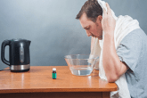 un homme fait une inhalation de vapeur d'eau chaude.