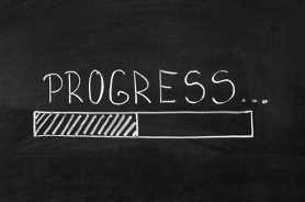 Progress écrit à la craie avec la moitié d'un rectangle coché. Cela montre le travail en cours et les progrès constatés.