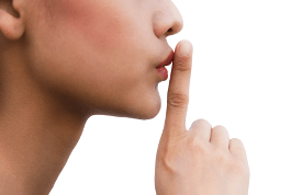 Une femme pointe l'index devant sa bouche pour indiquer le silence.